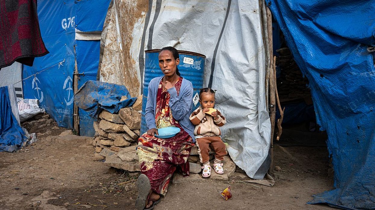 35-year-old Letebrahan sits outside the tent she shares with her one-year-old daughter, Zenehawit