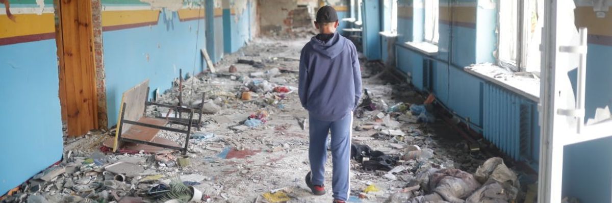 A 13-year-old walks away from the camera through a bombed high school hallway in Ukraine.