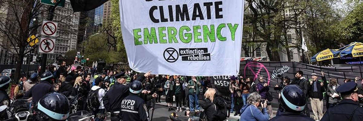 A banner is hung across a roadway while people participate in direct action with Extinction Rebellion on April 17, 2019 in New York City