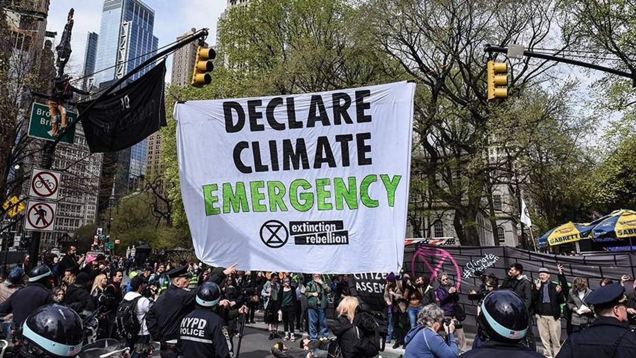 A banner is hung across a roadway while people participate in direct action with Extinction Rebellion on April 17, 2019 in New York City
