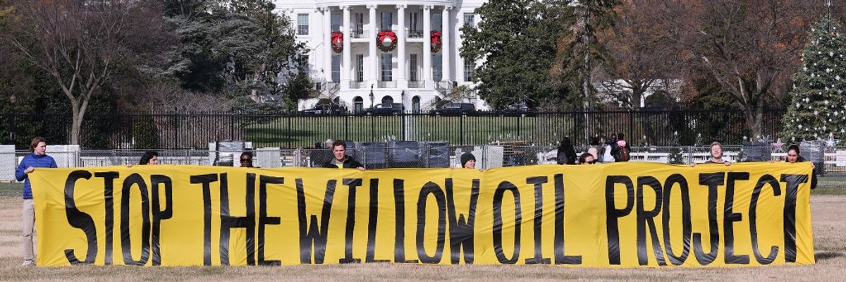 A banner outside the White House reads, "Stop the Willow oil project."