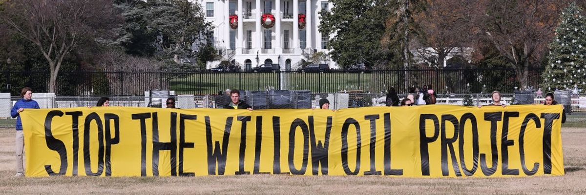A banner outside the White House reads, "Stop the Willow oil project."