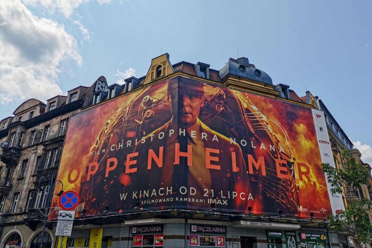 A billboard for the movie Oppenheimer on top of an old building.