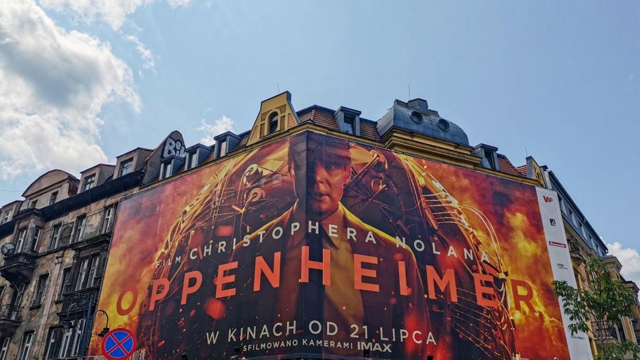 A billboard for the movie Oppenheimer on top of an old building.