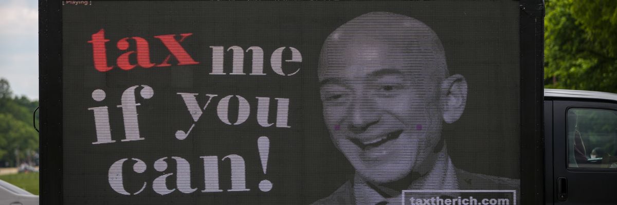 A billboard of Jeff Bezos reading, "Tax me if you can!"