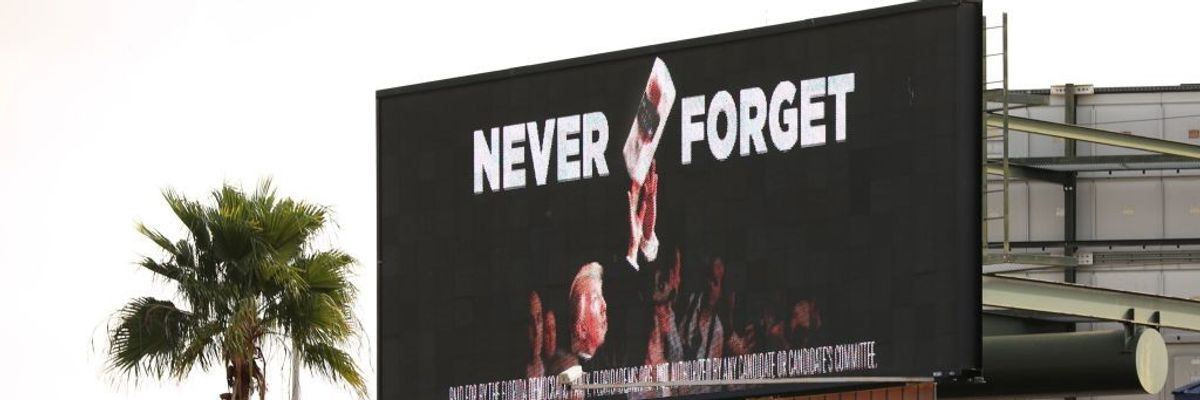 A billboard shows Trump throwing paper towels after Hurricane Maria.