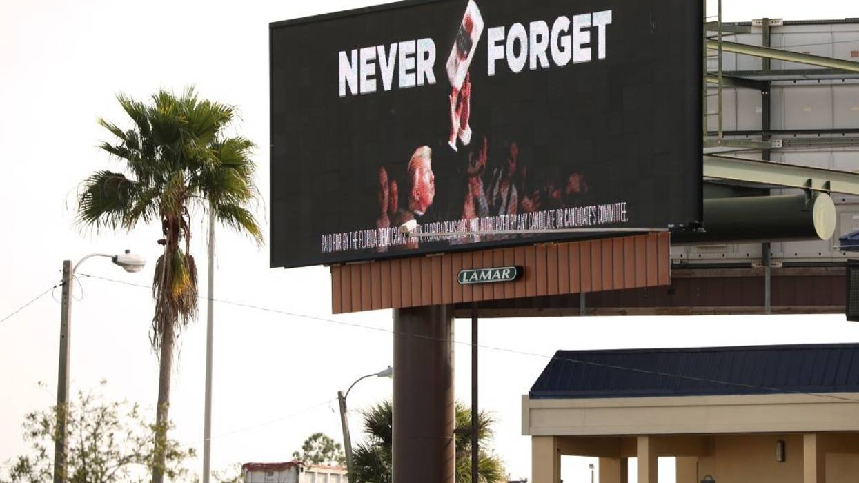 A billboard shows Trump throwing paper towels after Hurricane Maria.
