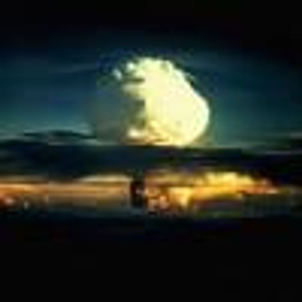 A billowing white mushroom cloud, mottled with orange, pushes through a layer of clouds during Operation Ivy, the first test of a hydrogen bomb