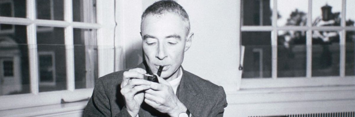 A black-and-white photo of J. Robert Oppenheimer smoking a pipe.
