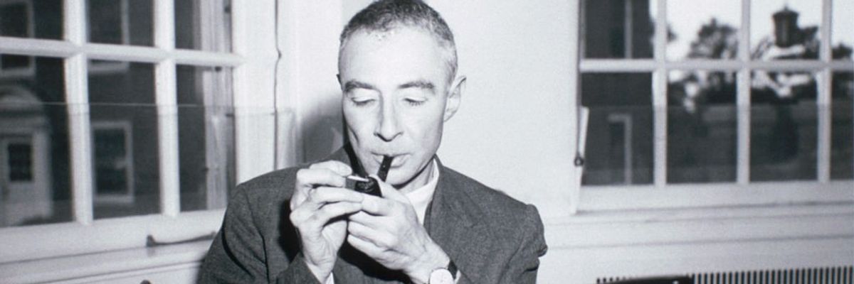 A black-and-white photo of J. Robert Oppenheimer smoking a pipe.