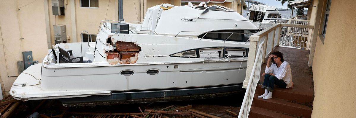 A boat resting against an apartment building after Hurricane Ian