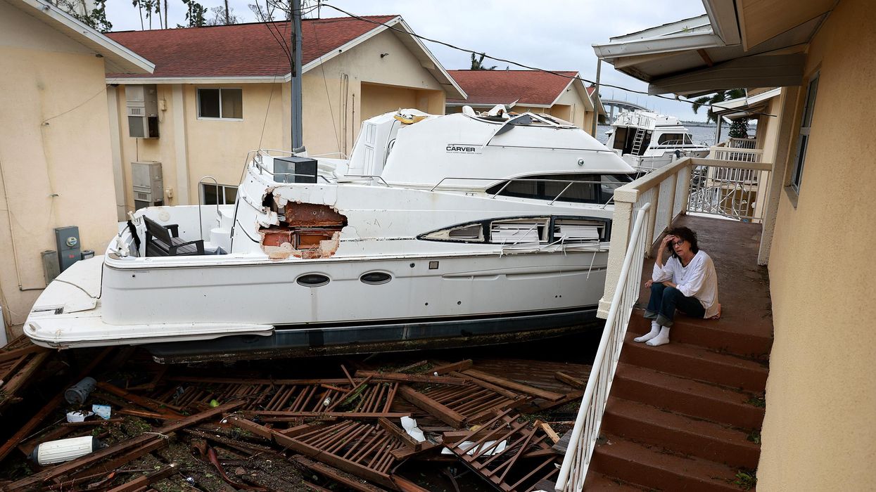 A boat resting against an apartment building after Hurricane Ian