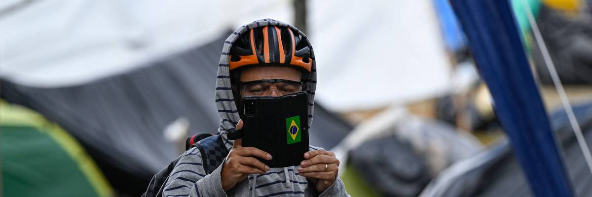 A Bolsonaro supporter takes pictures of the media