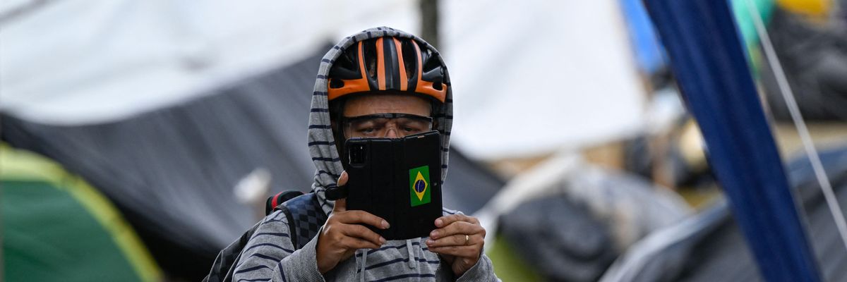 A Bolsonaro supporter takes pictures of the media