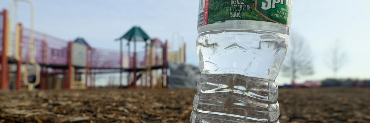 A bottle of Poland Spring water is pictured near a playground.