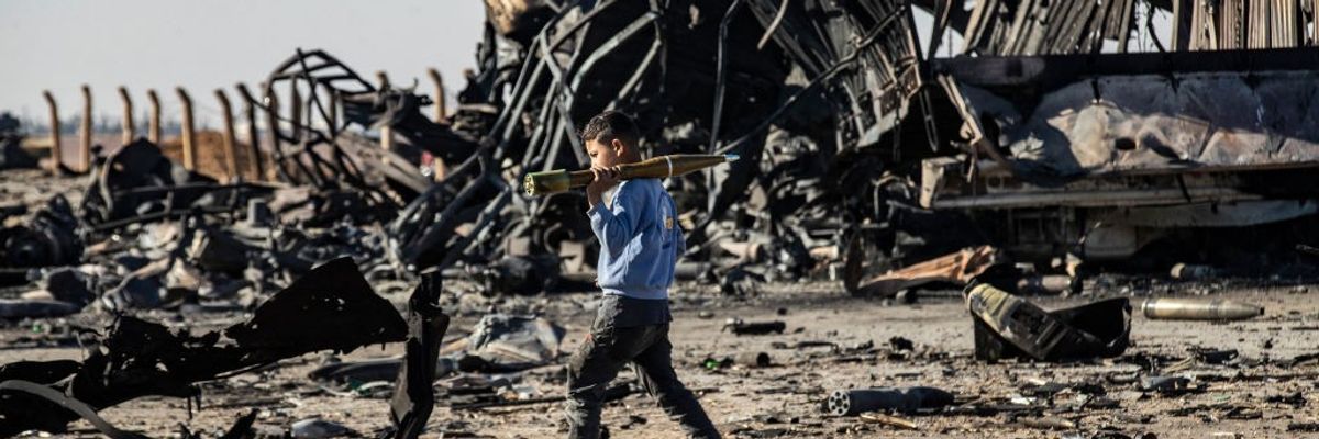 A boy carries unexploded RPG in Syria