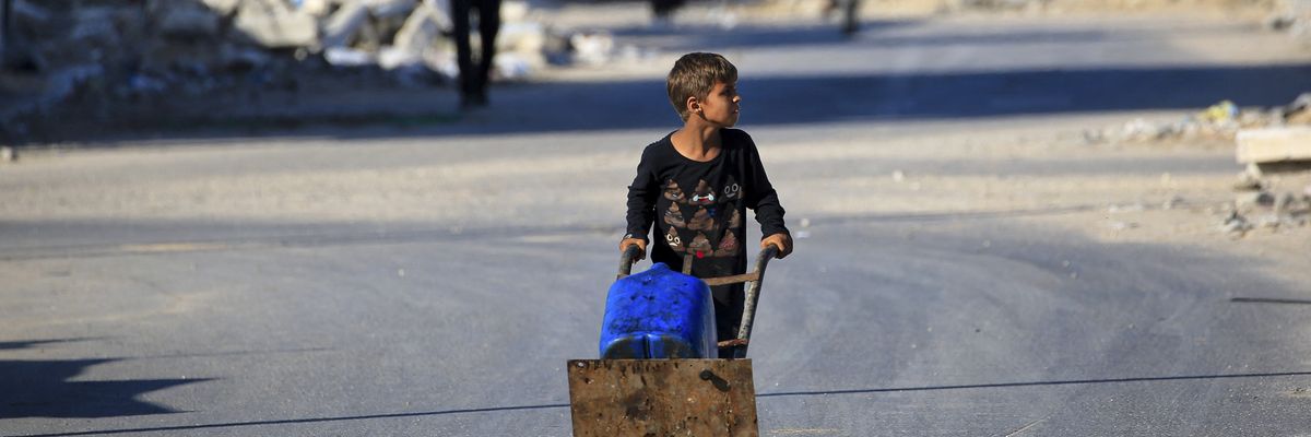 A boy carries water to al-Bureij refugee camp
