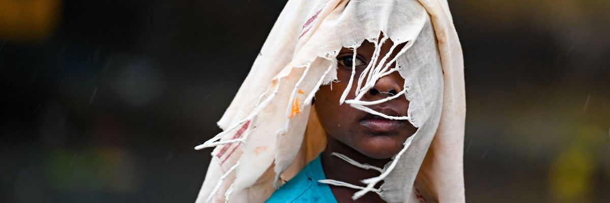 A boy covers himself with a cloth while walking along a street in Chennai, India on June 19, 2023.