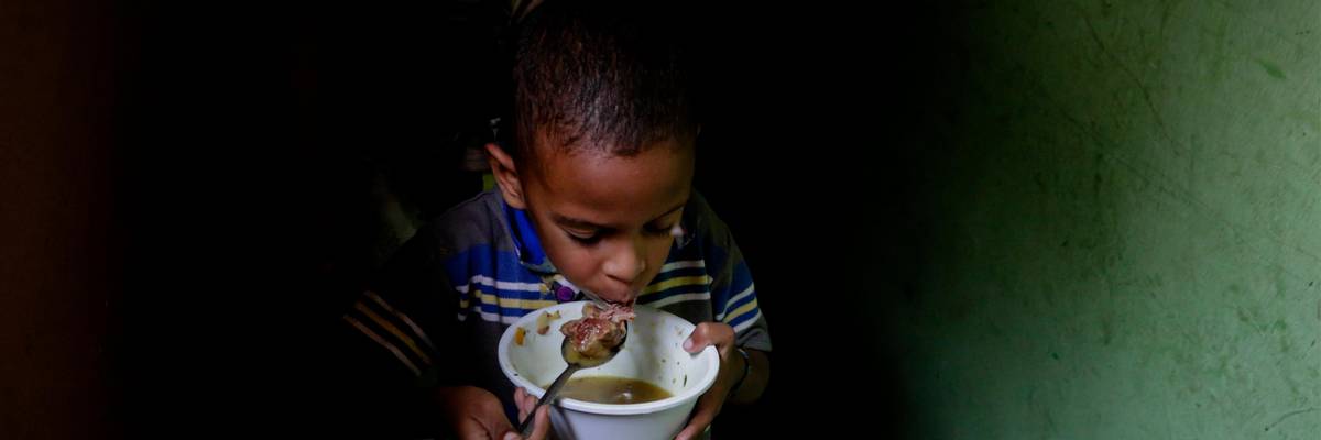 A boy eats soup prepared and donated by a local restaurant on April 12, 2019 in Caracas, Venezuela. (Photo: Eva Marie Uzcategui via Getty Images)