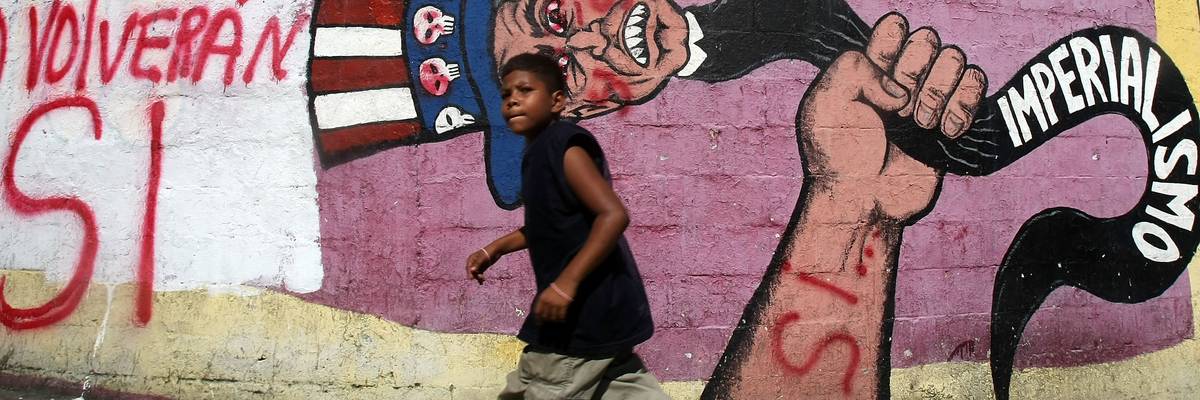 A boy walks past a mural in Caracas, Venezuela condemning US imperialism