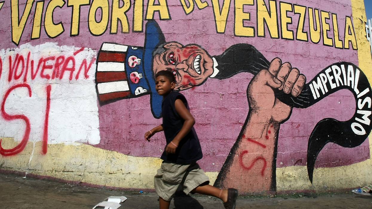 A boy walks past a mural in Caracas, Venezuela condemning US imperialism