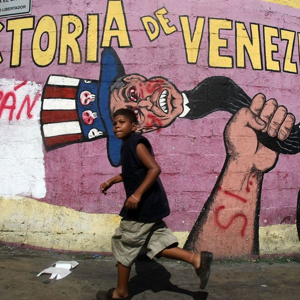 A boy walks past a mural in Caracas, Venezuela condemning US imperialism