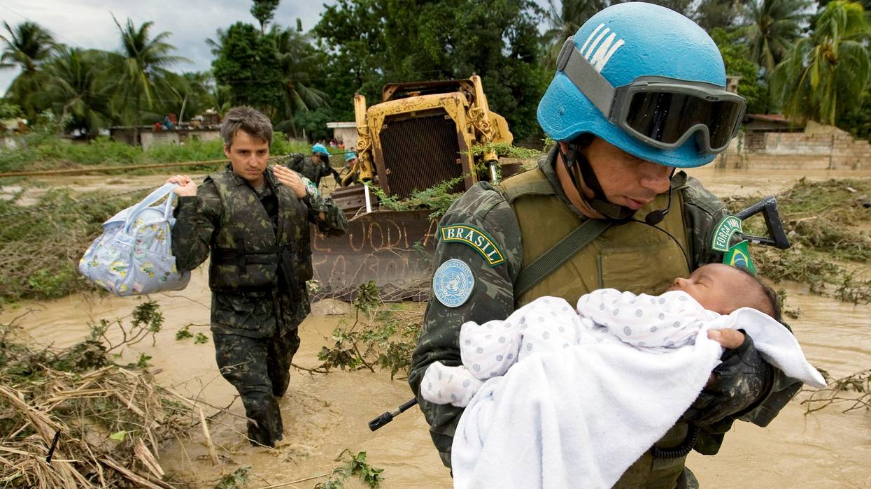 A Brazilian peacekeeper serving with the United Nations Stabilization Mission in Haiti (MINUSTAH) rescues a child from his flooded home in the Cite Soleil neighborhood of the Haitian capital of Port-au-Prince.
