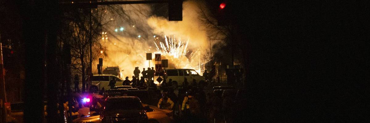 A bright explosion is seen as federal forces use less-lethal weapons in Minneapolis