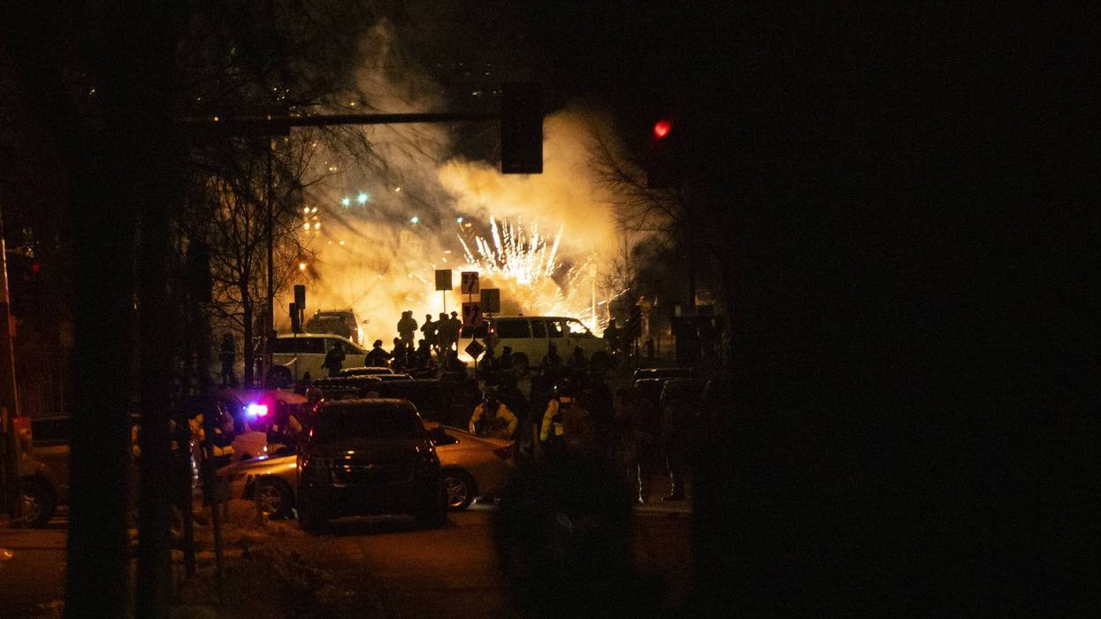 A bright explosion is seen as federal forces use less-lethal weapons in Minneapolis