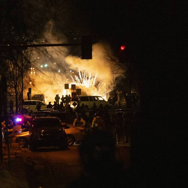 A bright explosion is seen as federal forces use less-lethal weapons in Minneapolis