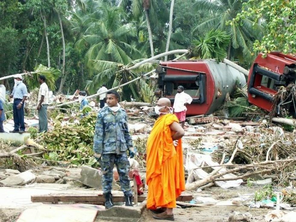 A Buddhist monk stands with a military officer in front of a train that was washed away by the waves in the southern village of Peraliya, killing over 1,000 people. (Photo: Amantha Perera/IPS)