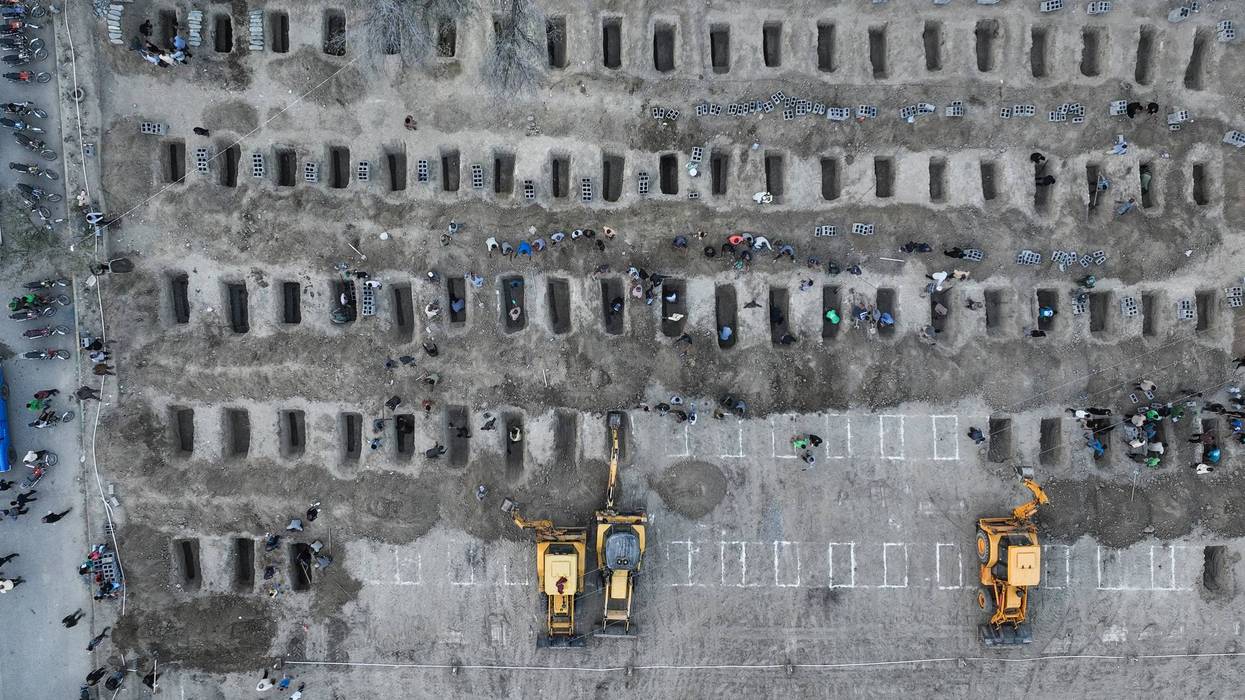 A bulldozer digs graves in Iran.