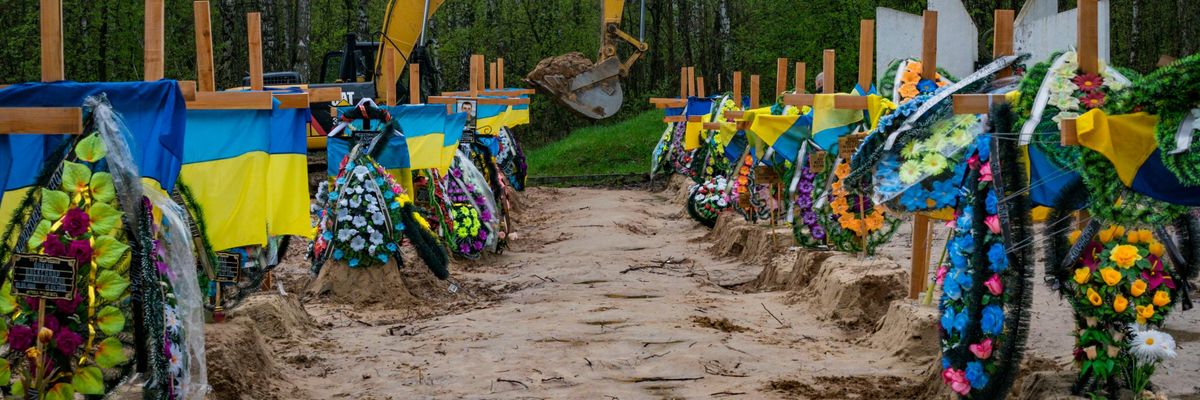 A bulldozer digs graves in Ukraine