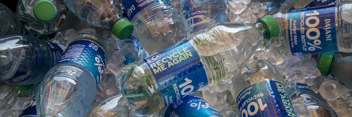 A bunch of recyclable water bottles in a bin.