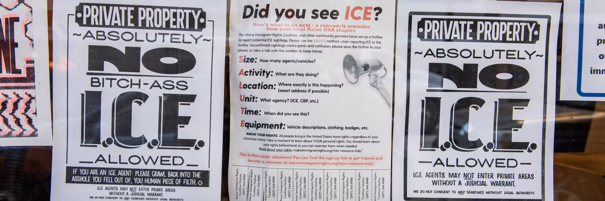 A business is seen with signs in its windows protesting US Immigration and Customs Enforcement