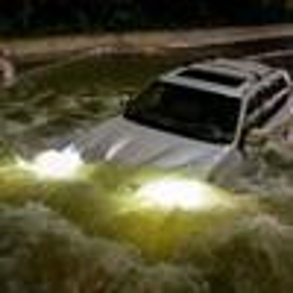 A car drives on a flooded street in New York Cty.
