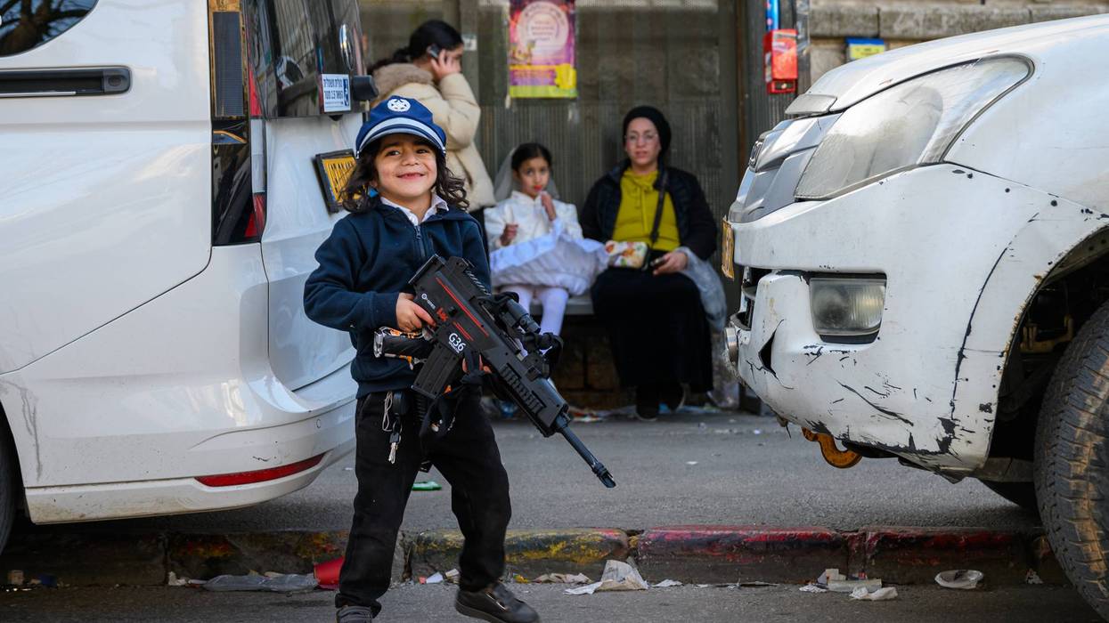 A child carries a toy gun in Jerusalem.
