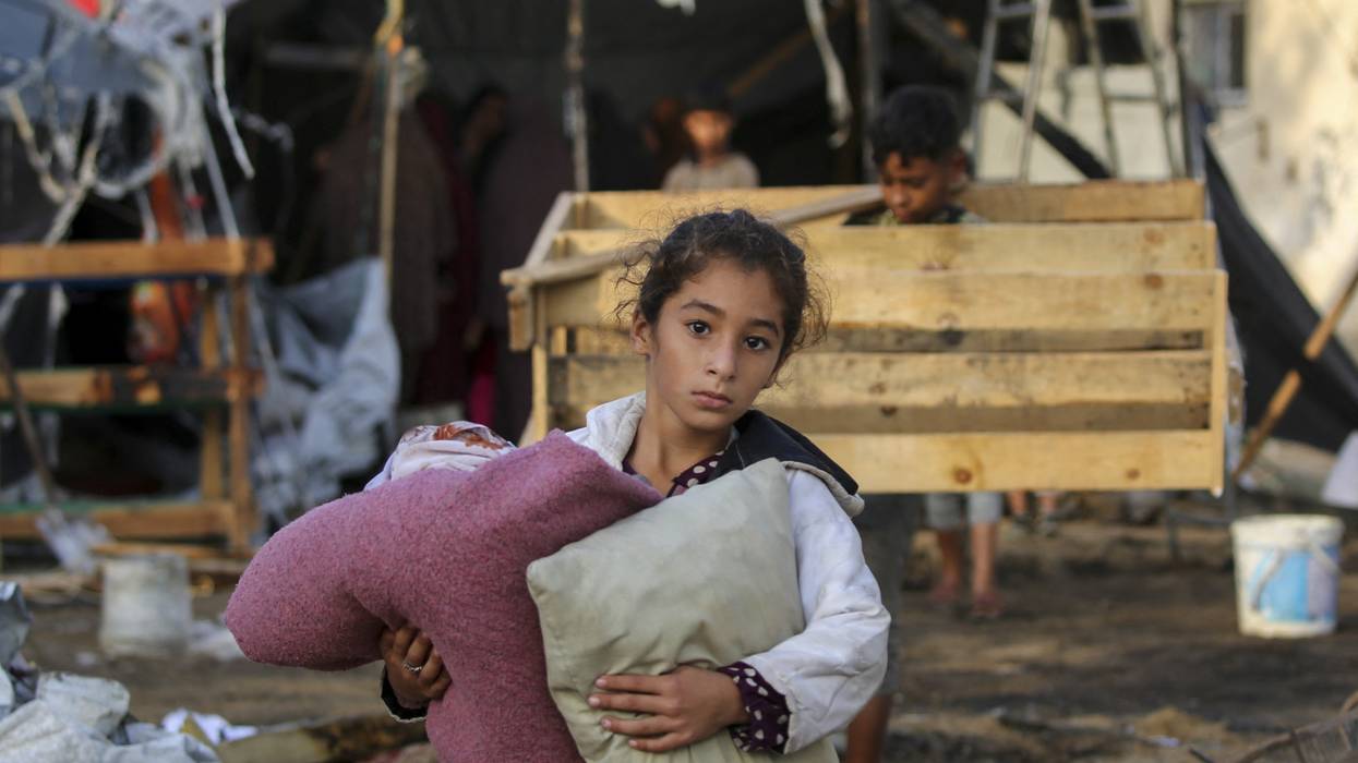 A child carries salvaged items following an Israeli airstrike