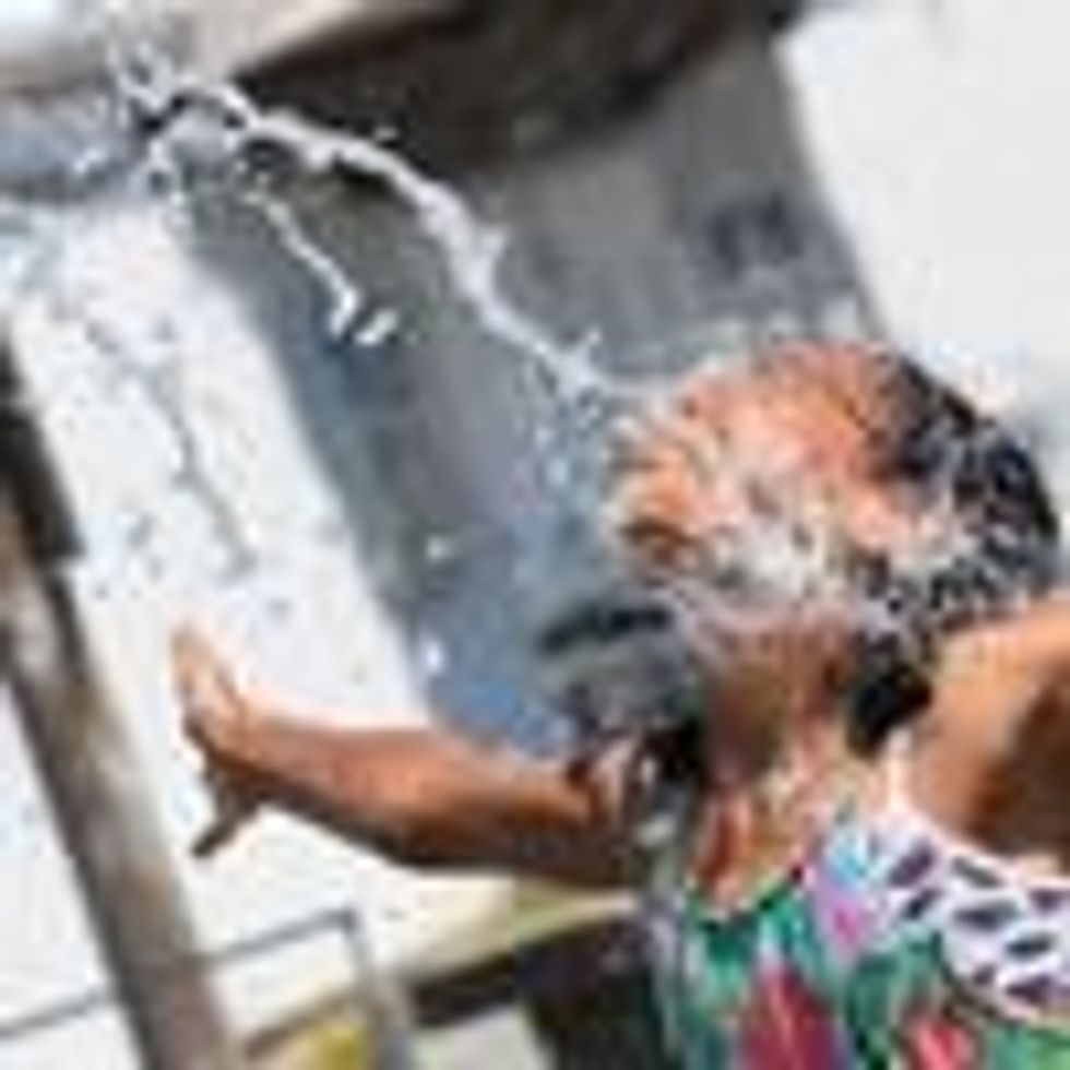 A child cools off at a community water park amid sweltering heat