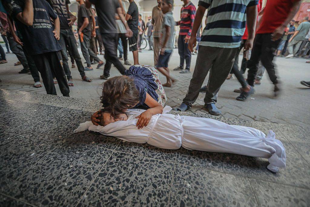 A child cries over another child's body in Gaza.