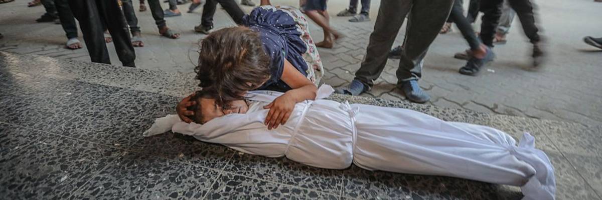 A child cries over another child's body in Gaza.