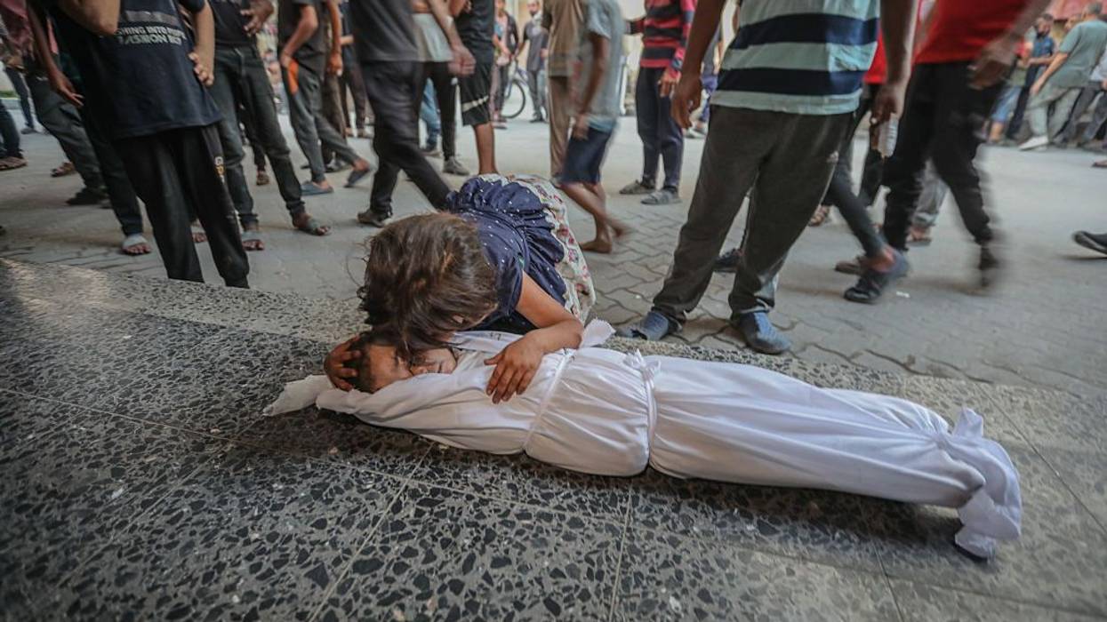 A child cries over another child's body in Gaza.