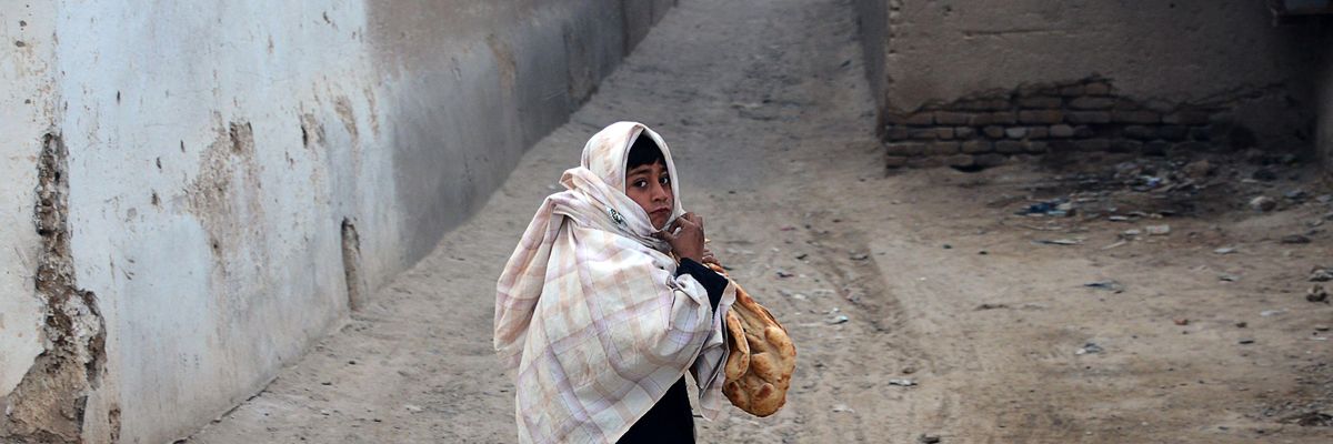A child holding bread walks early in the morning in Kandahar, Afghanistan on February 5, 2022.