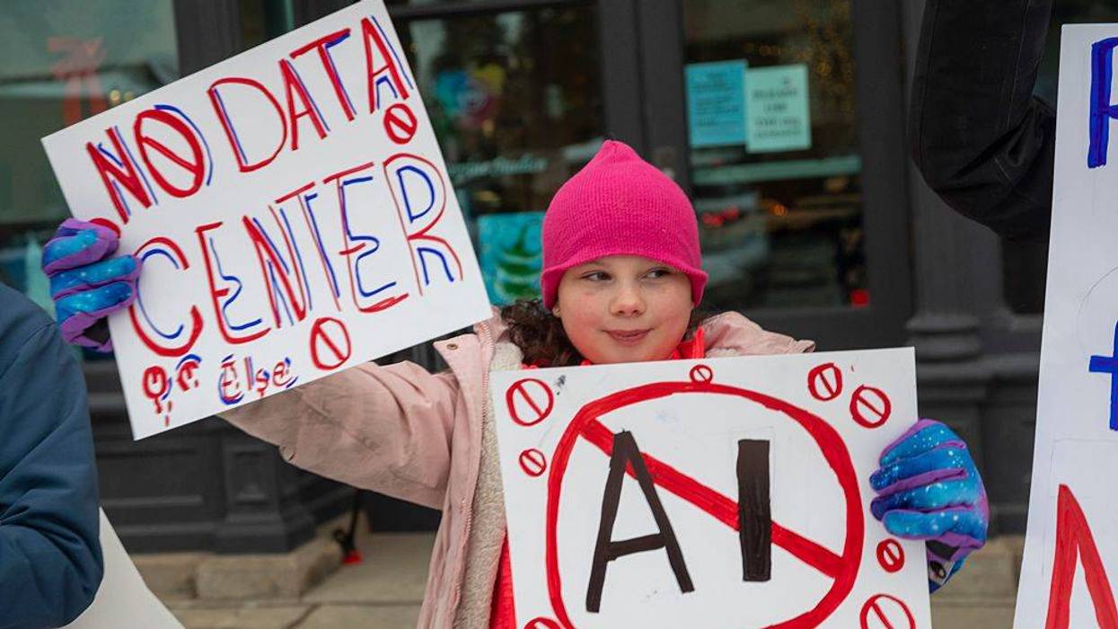 A child holds up a No Data Center sign.