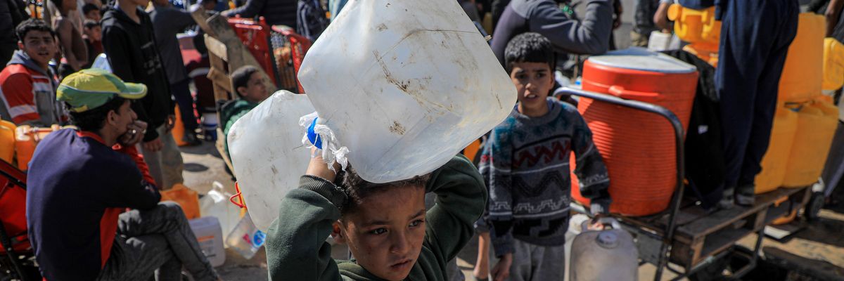 A child holds water jugs in Gaza.