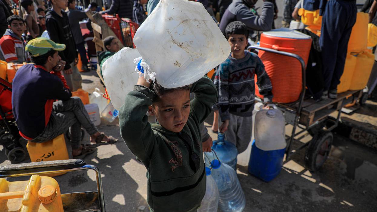 A child holds water jugs in Gaza.