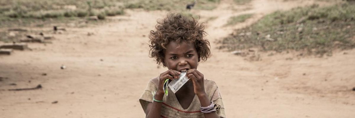 A child in Madagascar eats a nutritional supplement distributed by an NGO.