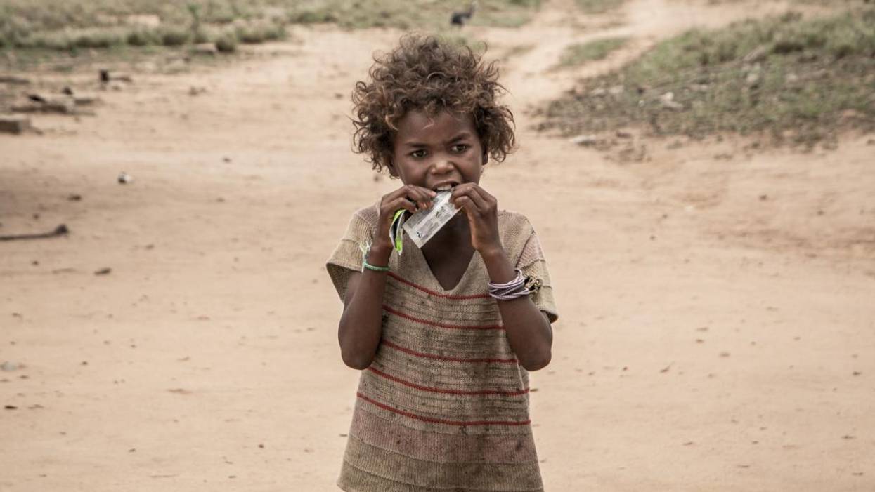 A child in Madagascar eats a nutritional supplement distributed by an NGO.