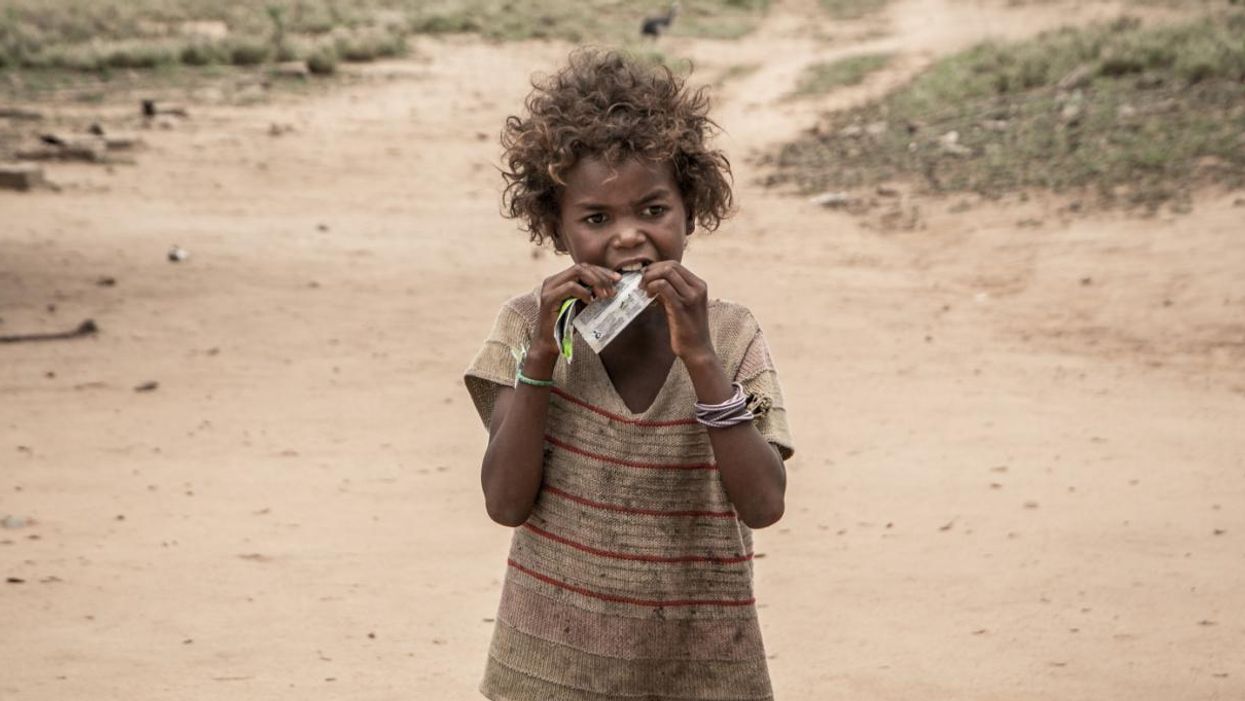 A child in Madagascar eats a nutritional supplement distributed by an NGO.