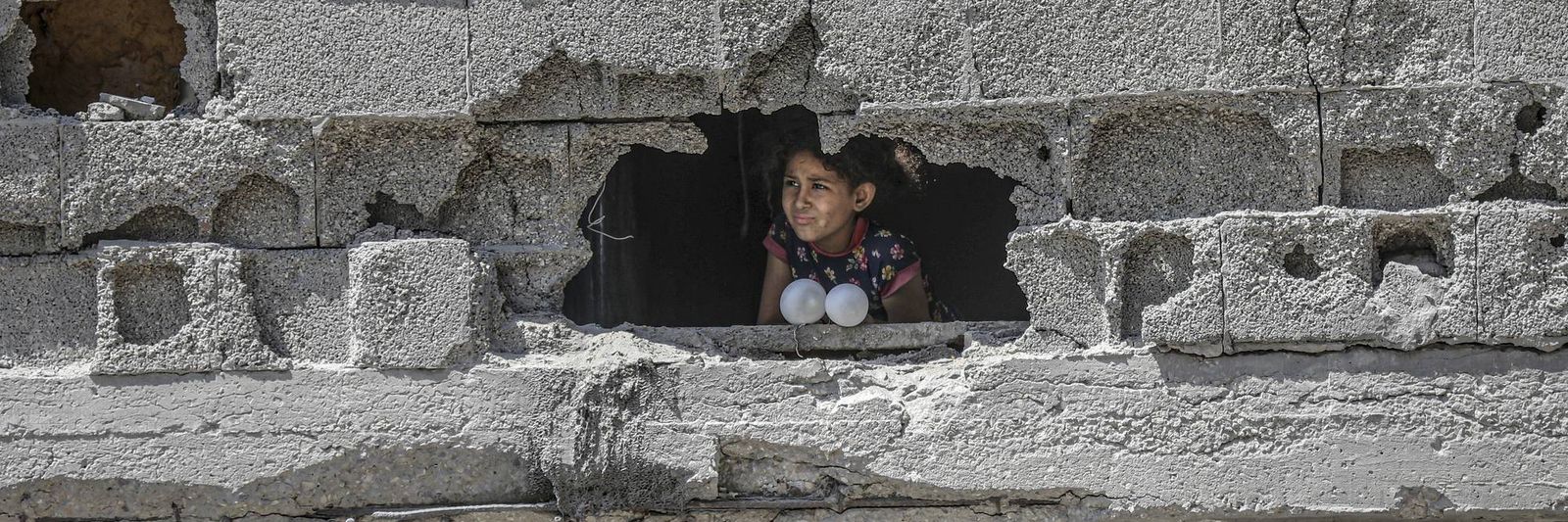 a-child-peers-through-a-hole-in-a-damaged-concrete-wall.jpg?id=68053852&width=1200&height=400&coordinates=0%2C524%2C0%2C143